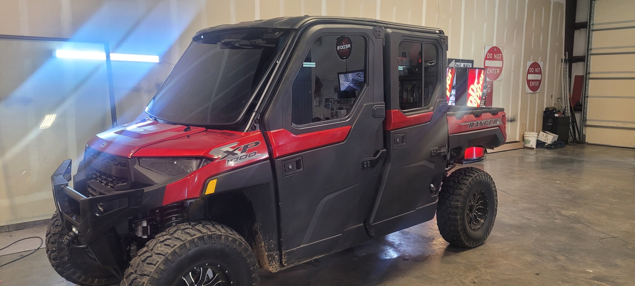 Red and black Ranger utility vehicle in garage